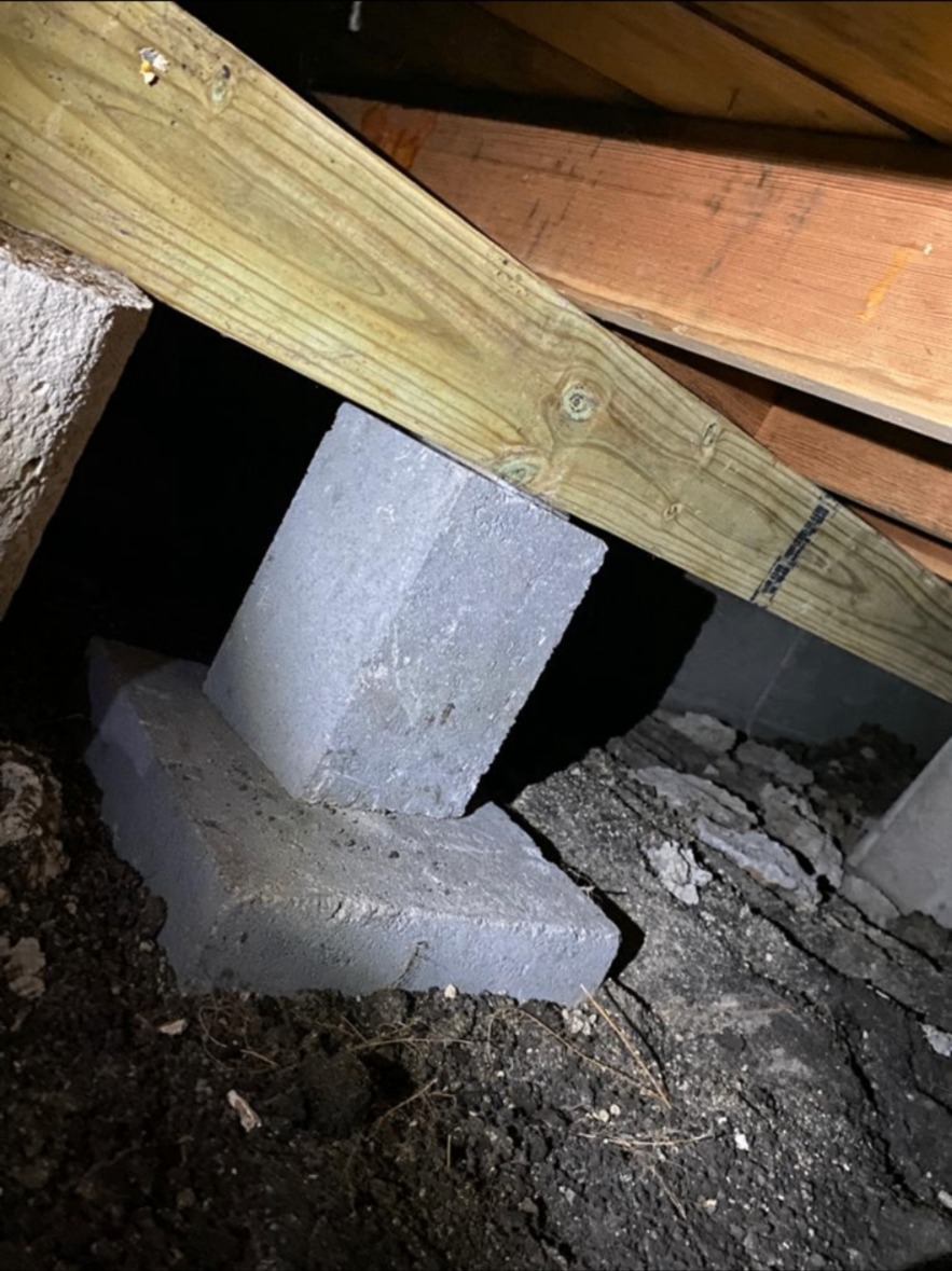Concrete block pier supporting a new beam in a crawl space