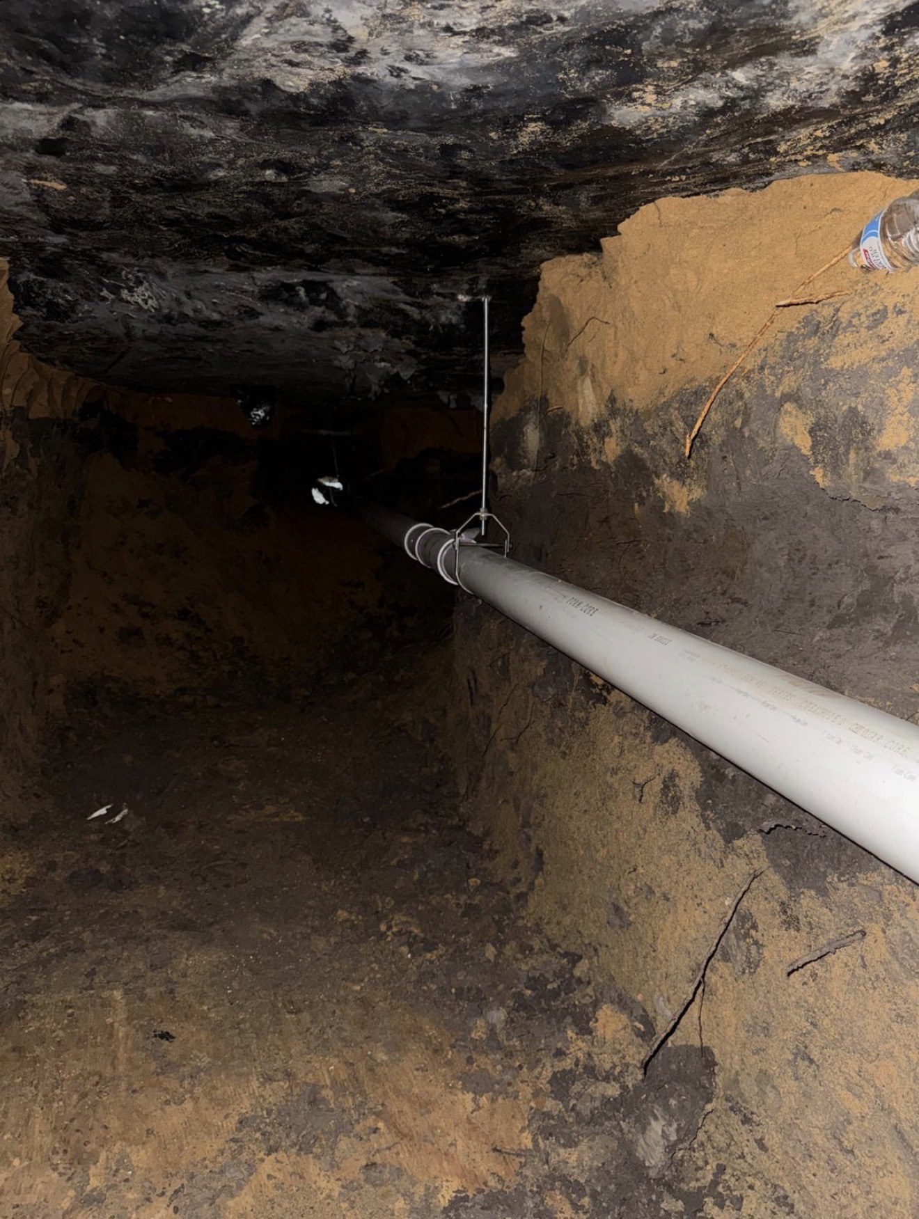 Completed tunnel plumbing run beneath a slab foundation