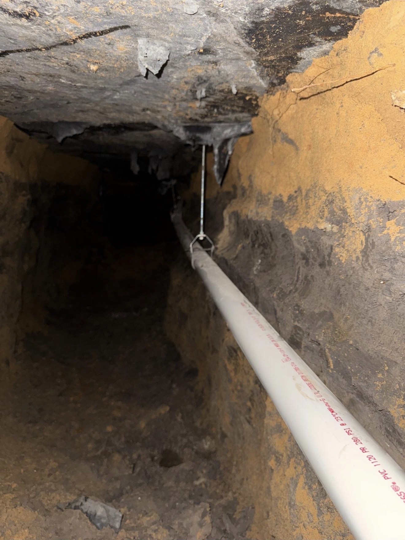 Crew working inside a tunnel beneath a home's foundation