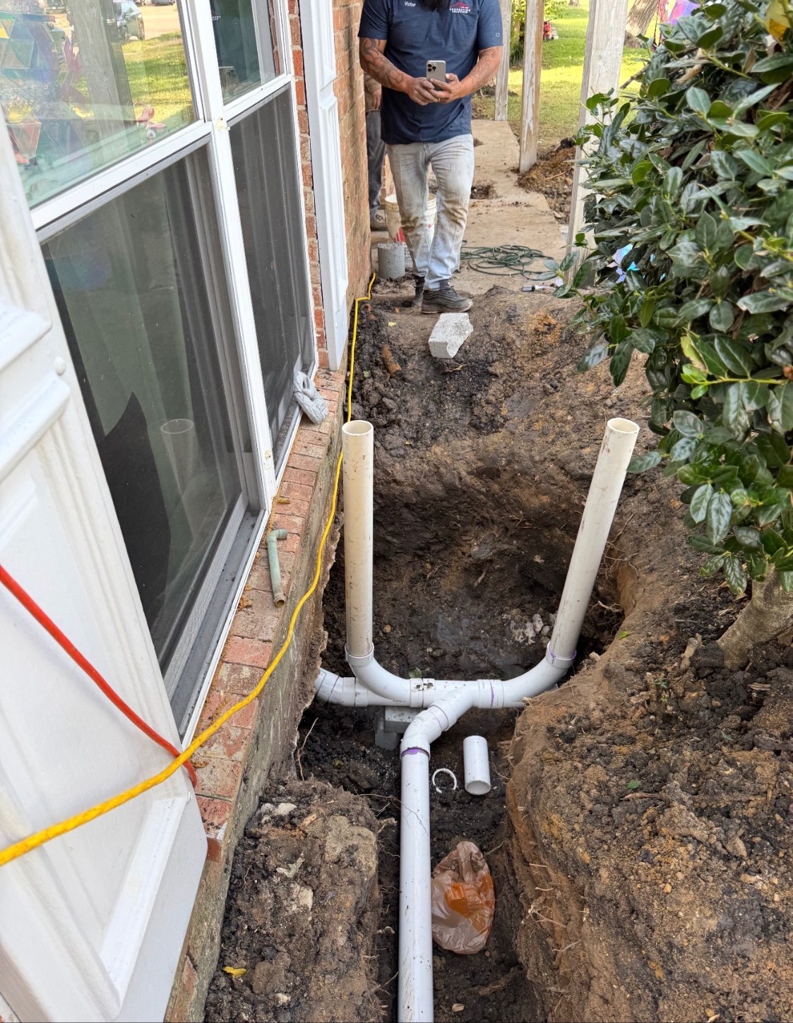 NTX crew excavating along a home's exterior to reach plumbing lines