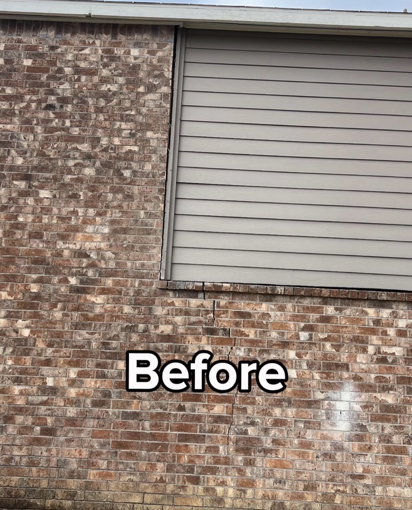 Brick wall with a stair-step foundation crack before repair