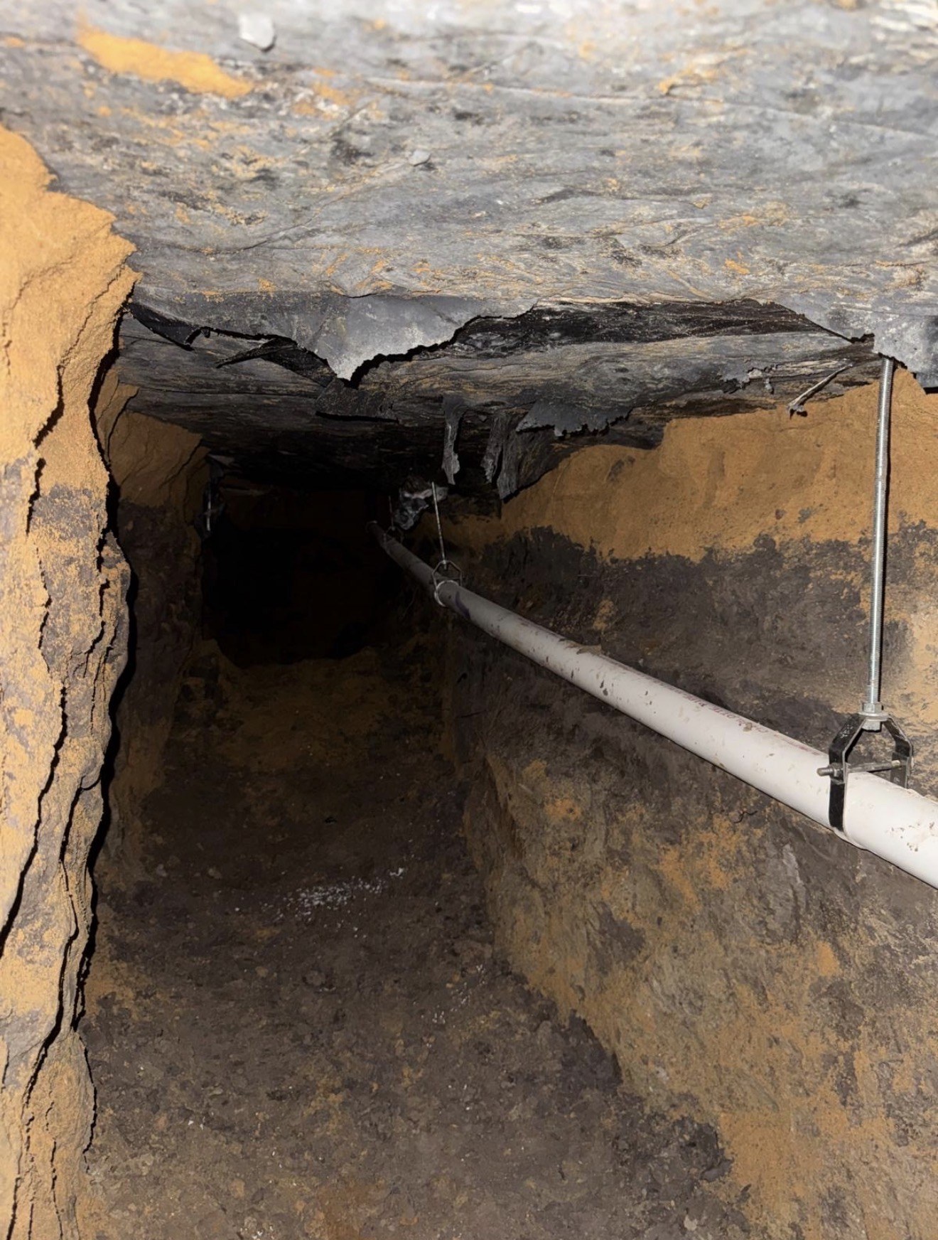 Hand-dug tunnel beneath a slab foundation with new plumbing lines