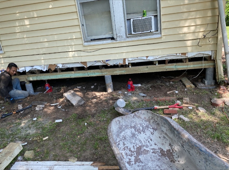 Crew jacking up a pier and beam home to level it