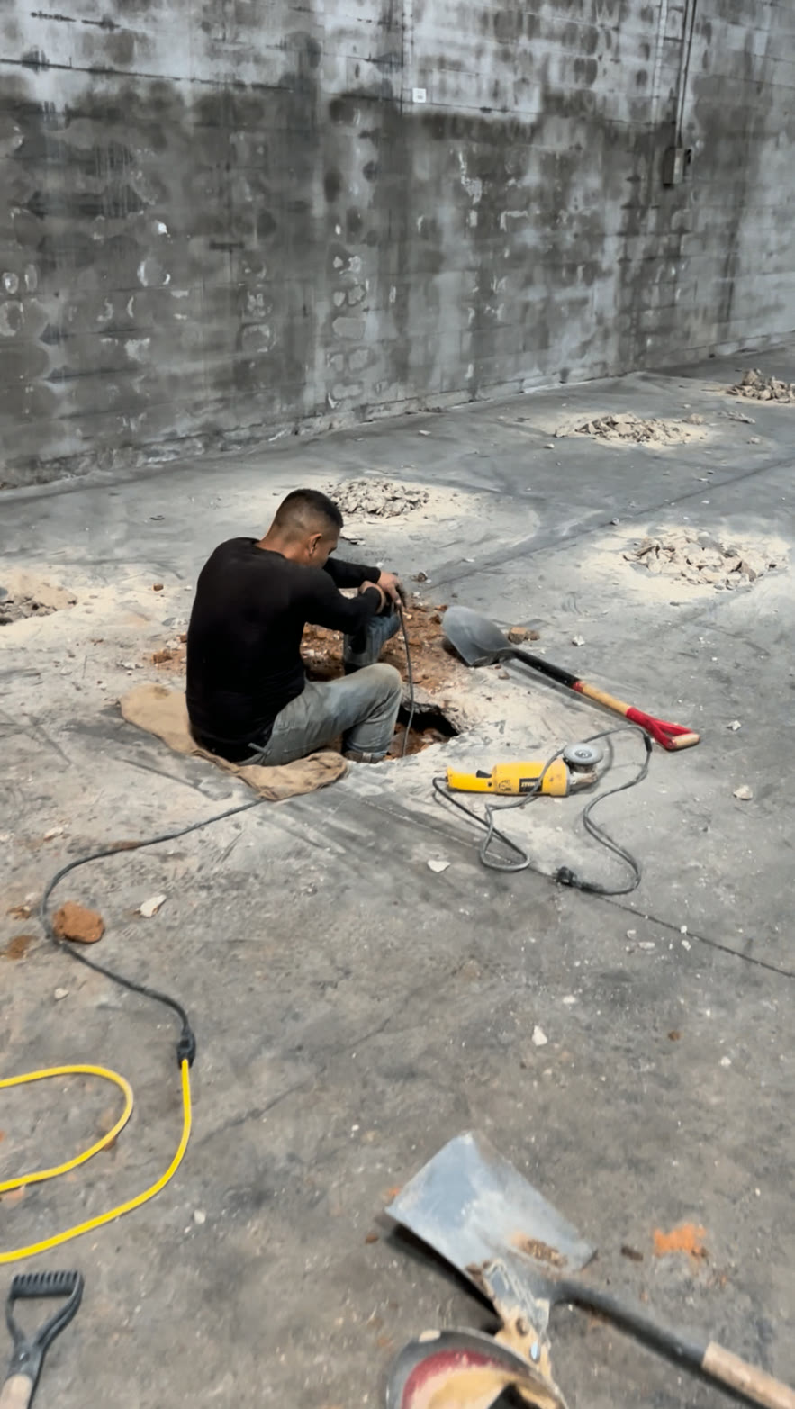 Crew member breaking out slab for interior foundation repair
